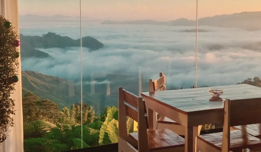 Traditional wood cabin exterior with lush mountain greenery at New Year's Peak Resort